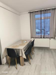 a dining room with a table and chairs and a window at Mountain view in Baia Mare