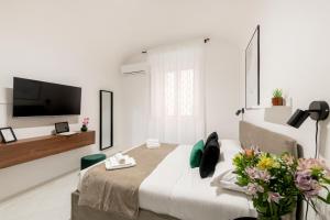 Un dormitorio blanco con una cama y un televisor de pantalla plana. en White Flat Sanniti, en Roma