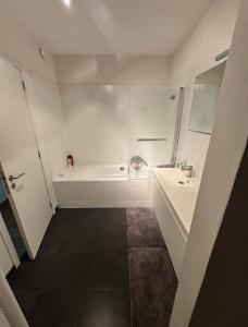 un bagno bianco con vasca e lavandino di Le Refuge Historique WIFI - Parking - Confort a Bruxelles