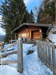chata z bali na śniegu z płotem w obiekcie Walters Hütte w mieście Tulfes