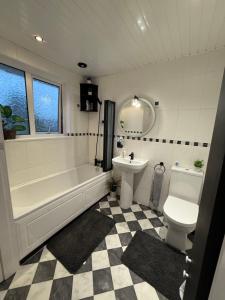 a bathroom with a tub and a toilet and a sink at Room at quiet location close to Belfast in Carnmoney +35 photos