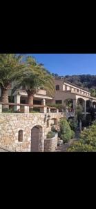 a large building with palm trees in front of it at Villa loucisa Nice piscine vue mer 8 chambres 24 couchages in Nice