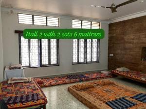 a room with beds and a sign that reads hall with cats and mattress at decent home stay in Belgaum