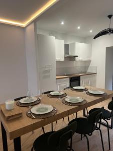 a kitchen with a wooden table with chairs and a dining room at Appartement rénové hypercentre-Charleville-10p in Charleville-Mézières