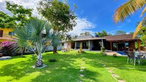 a yard with a palm tree in front of a house at CasaBelgaBrasil in Prado