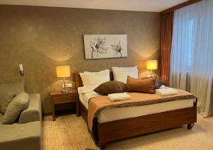 een slaapkamer met een bed met 2 lampen en een stoel bij Apartments B137 & B027 - Aparthotel Vučko in Jahorina