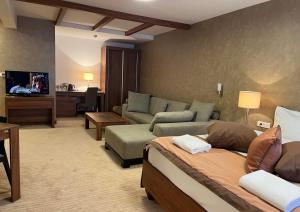 een grote woonkamer met een bank en een woonkamer met een bank bij Apartments B137 & B027 - Aparthotel Vučko in Jahorina