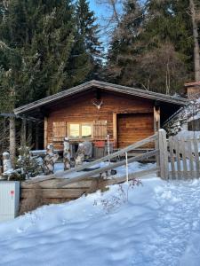 chata z bali na śniegu z płotem w obiekcie Walters Hütte w mieście Tulfes