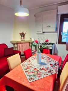 a kitchen with a table with a red table cloth at La Casa di Brandolice in Vivo dʼOrcia