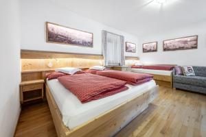 a bedroom with two beds and a couch at Apartment Ciasa Laoi in San Cassiano