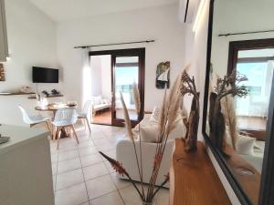 a kitchen and living room with a table and chairs at TAVOLARA MAGIC HOUSE-vista mare in Porto San Paolo +17 photos