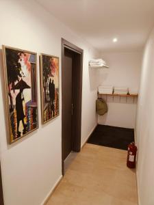 a hallway with paintings on the walls of a room at Relaxrooms, room with 2 single beds in Agios Georgios +10 photos