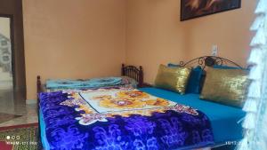 a bedroom with two beds with a blue comforter at Maison Touria in Ouzoud