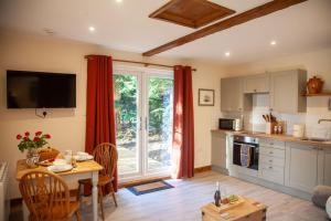 a living room with a table and a kitchen at Hayne Barn Estate 6 Luxury Lodges with private hot-tubs AND 1 studio without hot-tub in Hythe