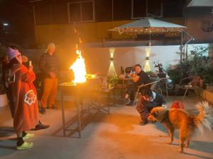 a group of people standing around a fire with a dog at shadow climers guest house in Yangshuo