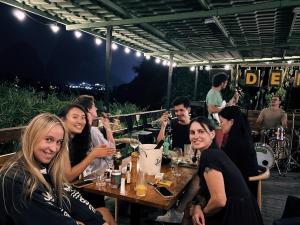 a group of people sitting at a table with drinks at shadow climers guest house in Yangshuo