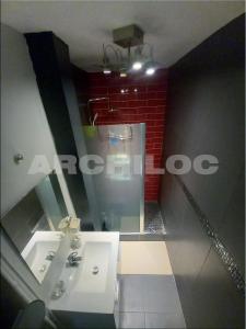 a bathroom with a white sink and a red brick wall at L'incontournable de Paris la Défense in Puteaux +24 photos