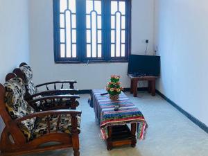 a room with chairs and a table with flowers on it at Sparrow Villa in Talpe