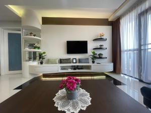 クチンにあるRiverbank Suites 805のリビングルーム(テレビ、花のテーブル付)
