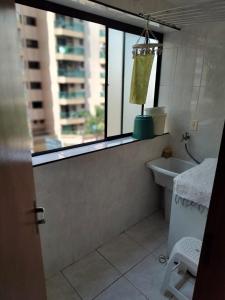 a bathroom with a window and a tub and a sink at Apartamento, Praia Grande, Canto do Forte in Praia Grande