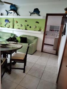 a living room with a table and a green couch at Apartamento, Praia Grande, Canto do Forte in Praia Grande