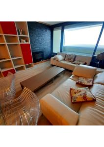 un salon avec un canapé et une chaise dans l'établissement Appartement "le chamois" Mongie centre 10 pers Bel appartement standing, à La Mongie 17 autres photos