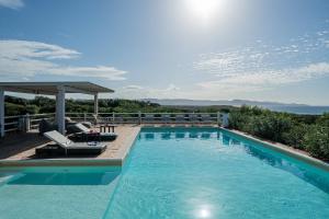 einen Pool mit zwei Stühlen und einem Pavillon in der Unterkunft Villa La Bitta in Badesi