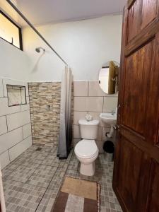 a bathroom with a toilet and a sink at Villa Granja Agua Azul-wi-fi-AC-6 Personas-parqueo in Agua Azul +61 photos