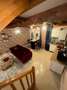 a living room with a red couch and a kitchen at Le 8 Appartement - Le Duplex II - parking gratuit - in Mâcon