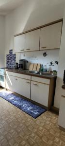 a kitchen with white cabinets and a counter top at Stellas Monteurswohnungen in Crimmitschau