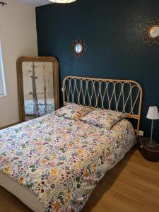 ein Schlafzimmer mit einem Bett mit geblümter Bettdecke in der Unterkunft Maison de vacances cosy in Avranches + 3 Fotos