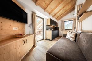 a living room with a couch and a flat screen tv at Apartment Ciasa Laoi in San Cassiano