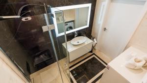 Un baño con ducha con lavabo y espejo. en Apartament ODNOWA z bezpośrednim widokiem na morze w Gardenia Dziwnów -, en Dziwnów 27 fotos más