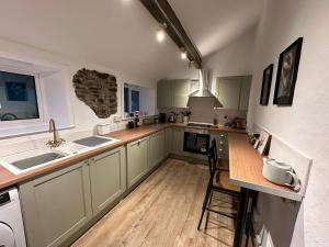a kitchen with green cabinets and a counter top at Ladybird Cottage in Barrowford