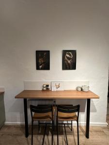 a table with two chairs and two pictures on the wall at Ladybird Cottage in Barrowford +5 photos