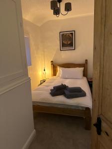 a bedroom with a bed with two towels on it at Ladybird Cottage in Barrowford