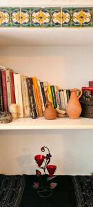 a shelf with books and vases on it at Dreaming Rooms - Sidi Bou Saïd in Sidi Bou Saïd