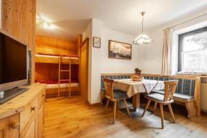 a dining room with a table and chairs and a bedroom at Apartment Ciasa Laoi in San Cassiano