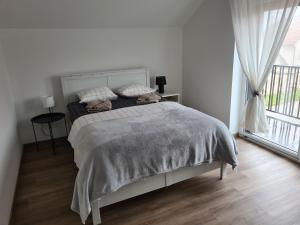 ein weißes Schlafzimmer mit einem Bett und einem Fenster in der Unterkunft Maya-K apartment near city center in Ljubljana