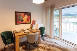 a dining room with a wooden table and green chairs at Deus silva in Filippiada