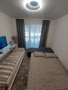 a bedroom with two beds in front of a window at Merak Bjelasnica in Bjelašnica