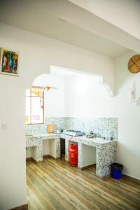 a room with two white tables and a wooden floor at Pamoja Beach Stays Hotel in Jambiani in Jambiani