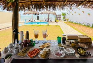 a table with food and drinks on a beach at Pousada Bikibu in Maracajaú