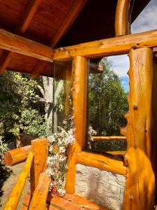 una ventana en una estructura de madera con flores. en Casa Huemul, en San Carlos de Bariloche