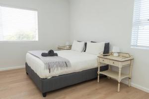 GqeberhaにあるVerdi Luxury Cottage 1の白いベッドルーム(ベッド1台、テーブル付)