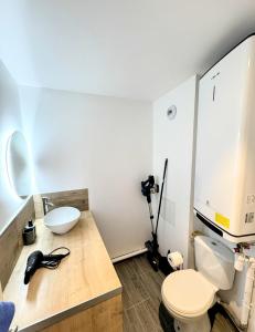 a bathroom with a white toilet and a sink at Terra Cotta 1er Étage in Abbeville +10 photos