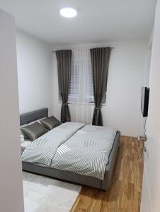 a bedroom with a bed and a window at Stan na dan Brcko -The Gold Nook in Brčko