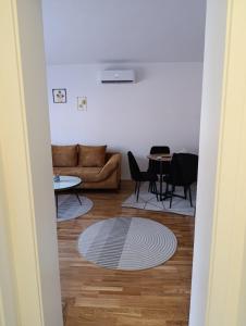 a living room with a couch and a table at Stan na dan Brcko -The Gold Nook in Brčko +2 photos