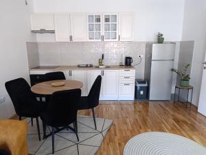 a kitchen with a table and chairs and a refrigerator at Stan na dan Brcko -The Gold Nook in Brčko