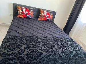 a black and white bed with two pillows on it at Apartment 2 camere 1,3 km Promenada Mall Capacitate 4 persoane in Craiova